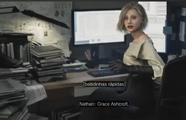 Alt =  Grace Ashcroft sentada em uma mesa de trabalho com dois monitores e pilhas de documentos. Ela olha para trás em direção à câmera.
legendas c: "[batidinhas rápidas]" indicando som, e "Nathan: Grace Ashcroft." identificando o personagem que fala.
